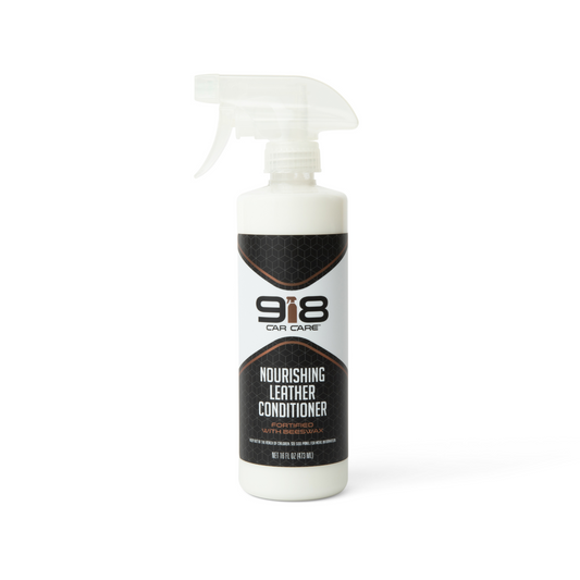 16fl oz white spray bottle with black trim of 918 Car Care Nourishing Leather Conditioner: Fortified With Beeswax. Both the subheading, and the spray bottle in the company logo, are brown.